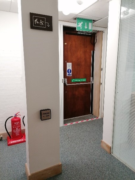 Corridor photo, facing exit, showing column with touchpad to open external door
