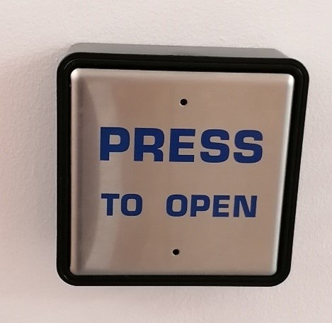 Close-up of button to open power-assisted door with Press to open label