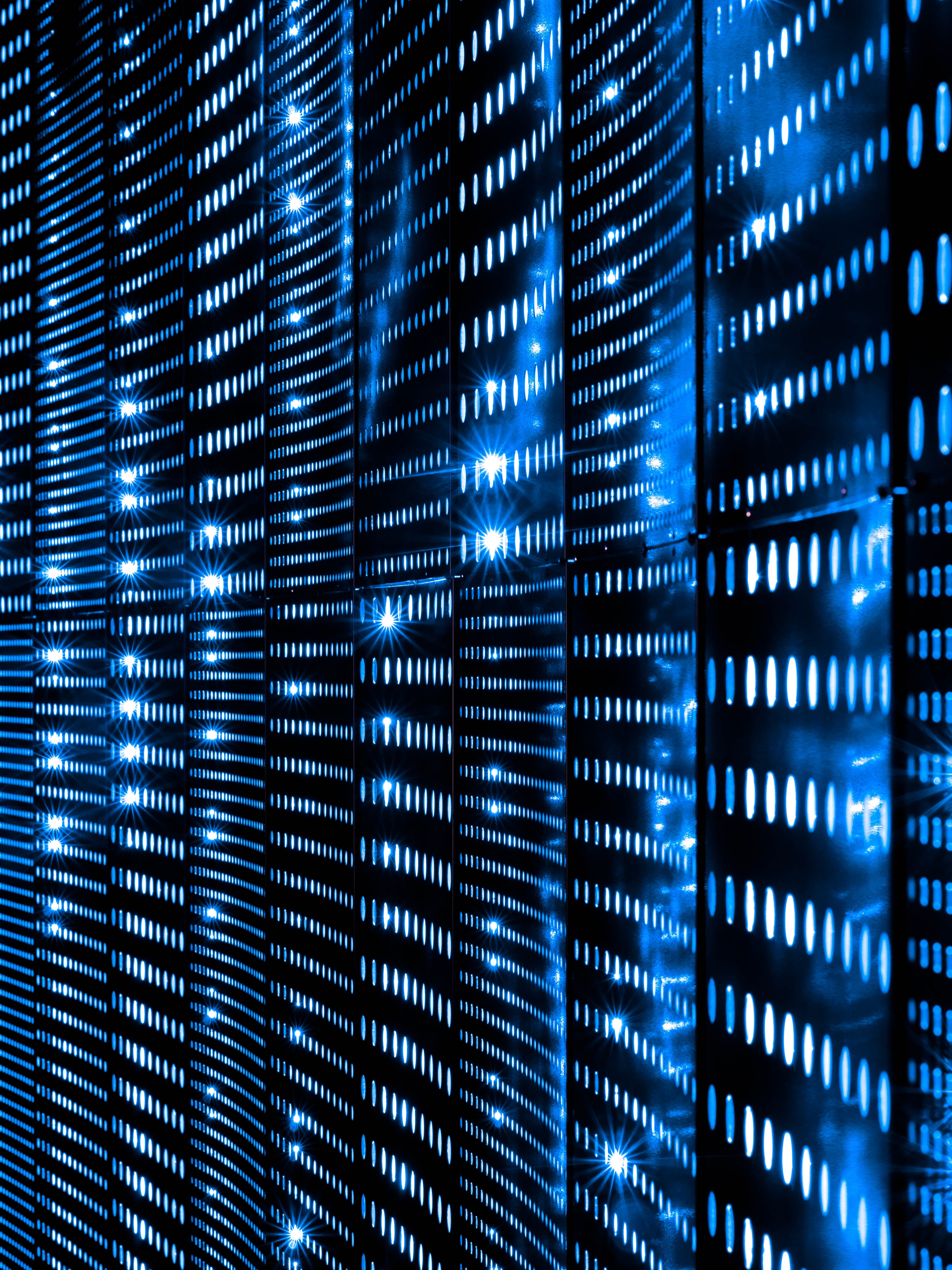 A row of blue lights from a computer server creates a decorative vertical pattern 